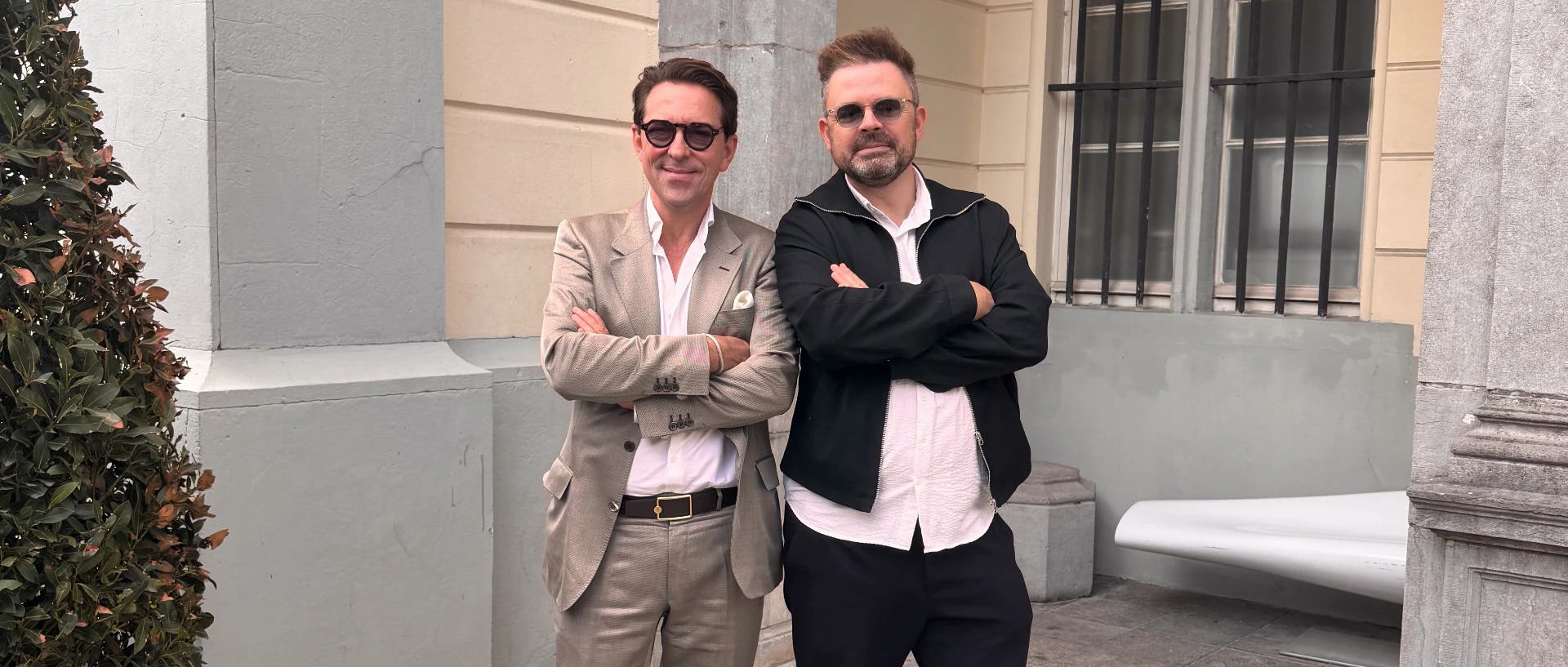 Carl De Moncharline (à gauche) et Sébastien Boussois Sébastien Boussois en Carl De Moncharline, armen gekruist, op een zonnige gekasseide binnenplaats in Brussel