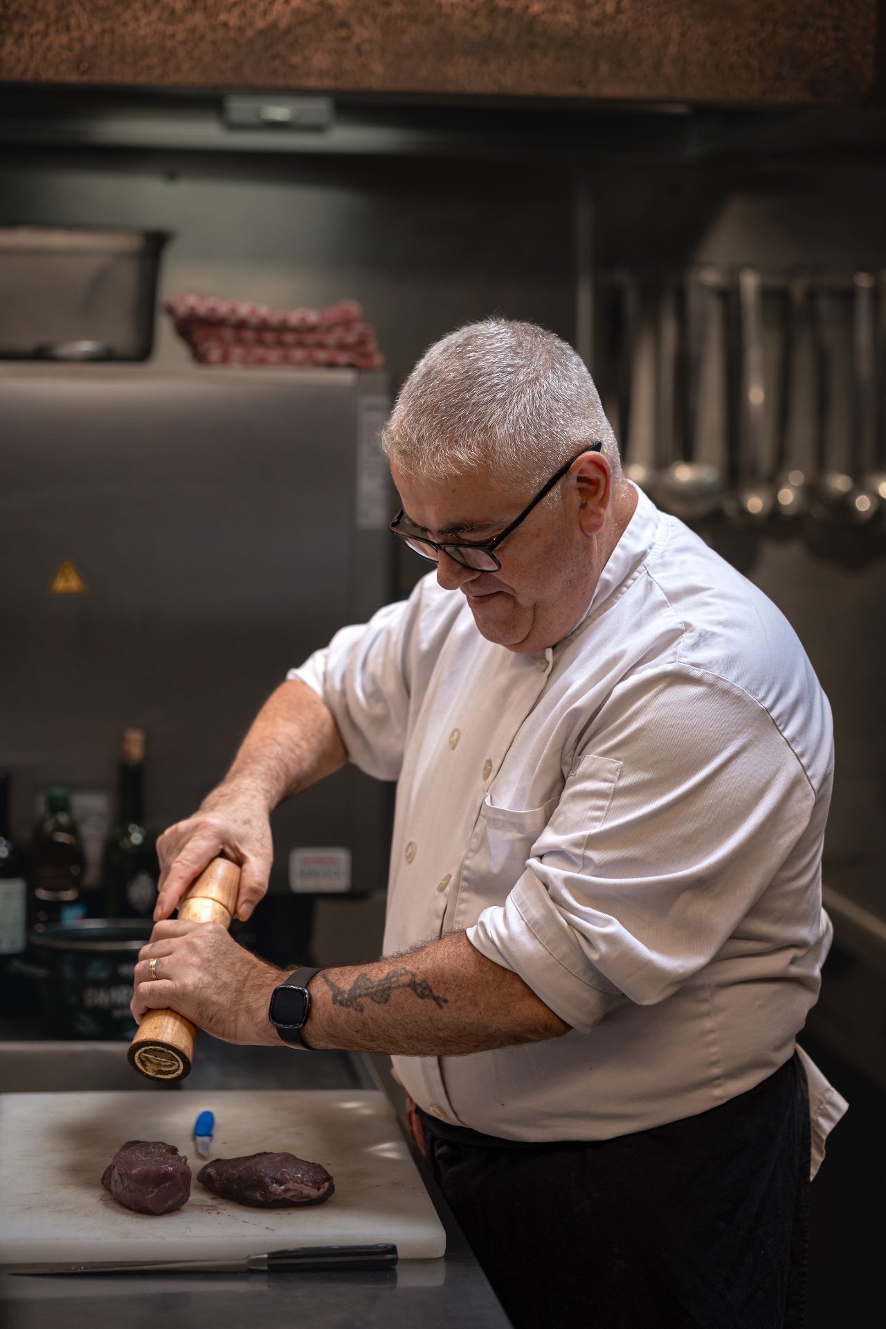 Portrait du chef cuisinier de La Roue d’Or en pleine préparation, coulisses d’une brasserie bruxelloise emblématique