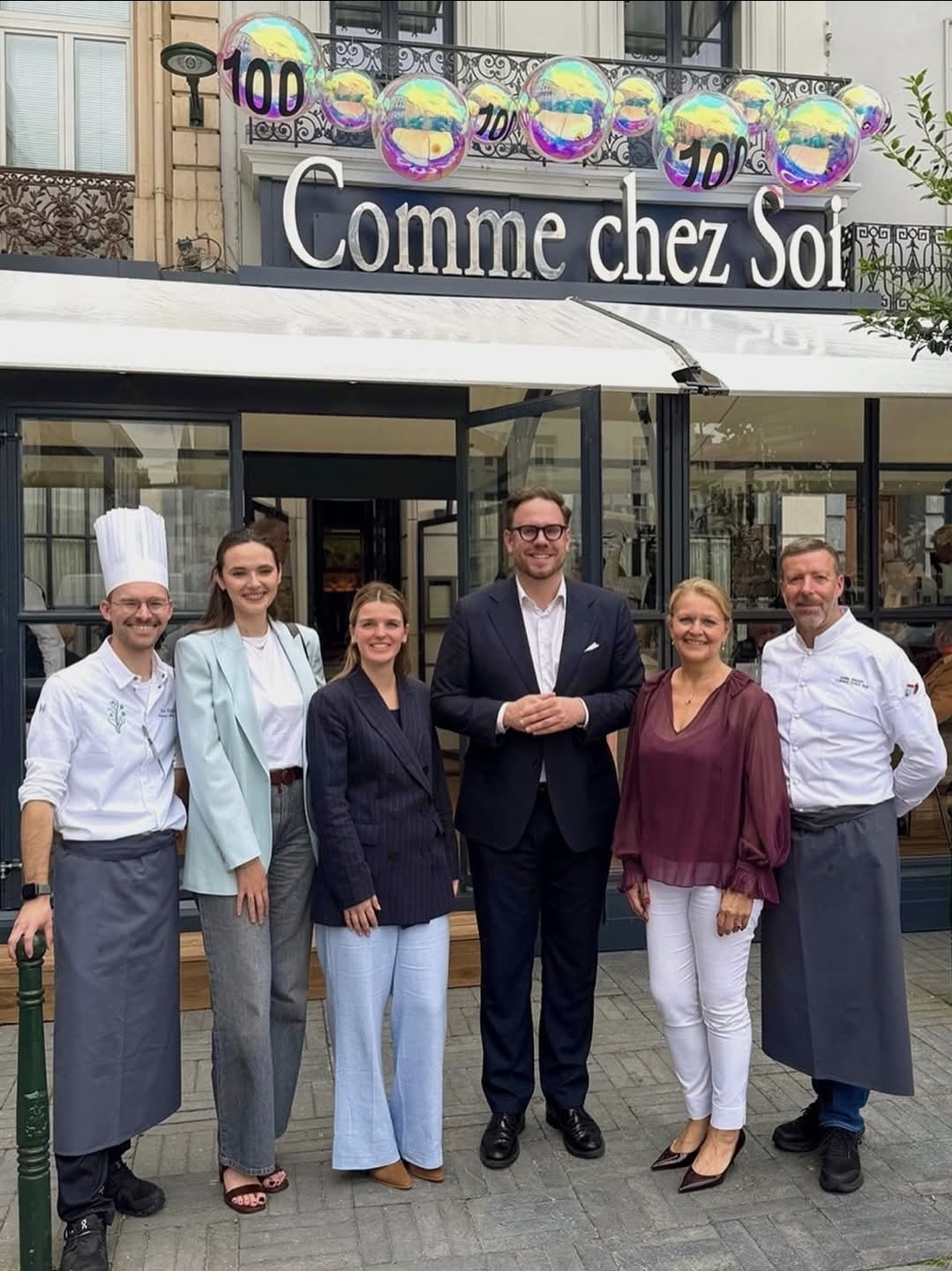 David Weytsman, la ministre Éléonore Simonet et la famille Wynants-Rigolet devant Comme Chez Soi, Place Rouppe, pour le centenaire