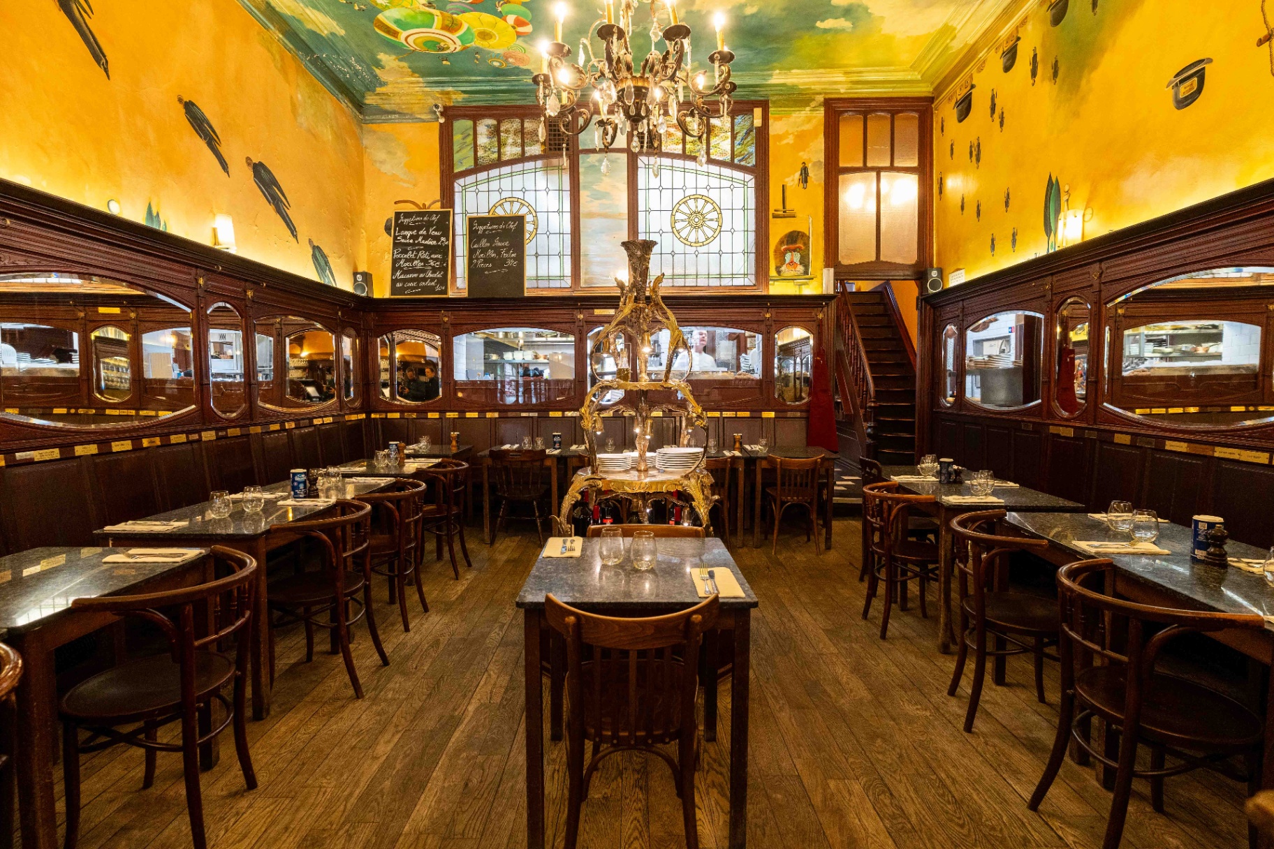 La Roue d’Or makes its debut in the Les Meilleurs Restaurants de Bruxelles guide La Roue d’Or dining room with yellow walls, stained glass and a painted ceiling