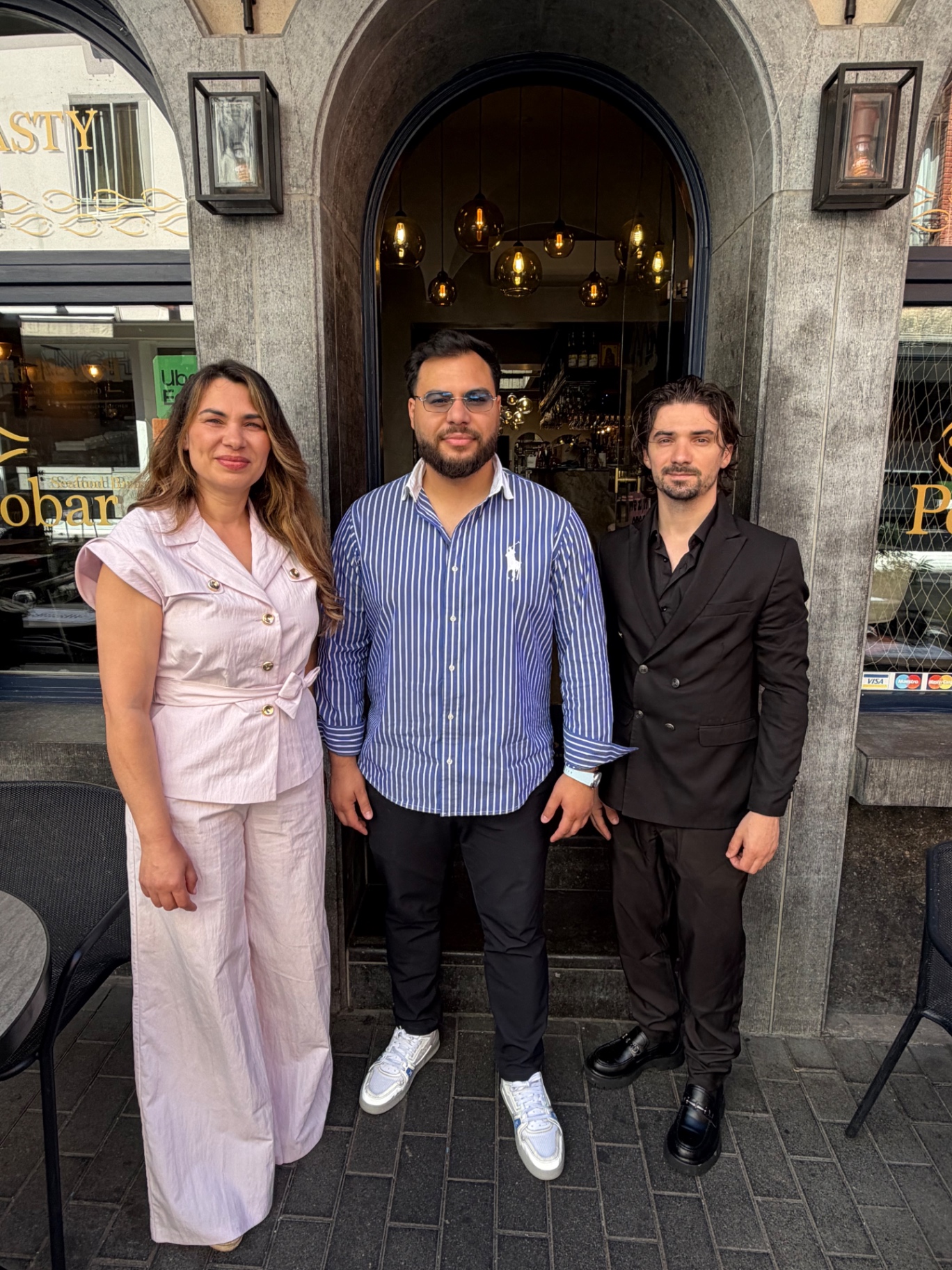 Trio de l’équipe Pescobar Brussels devant l’entrée arche en pierre du restaurant rue Jourdan