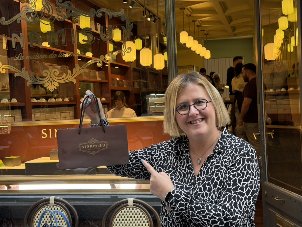 Floriane Bonnier devant la vitrine Sinamisu avec un sac de la maison