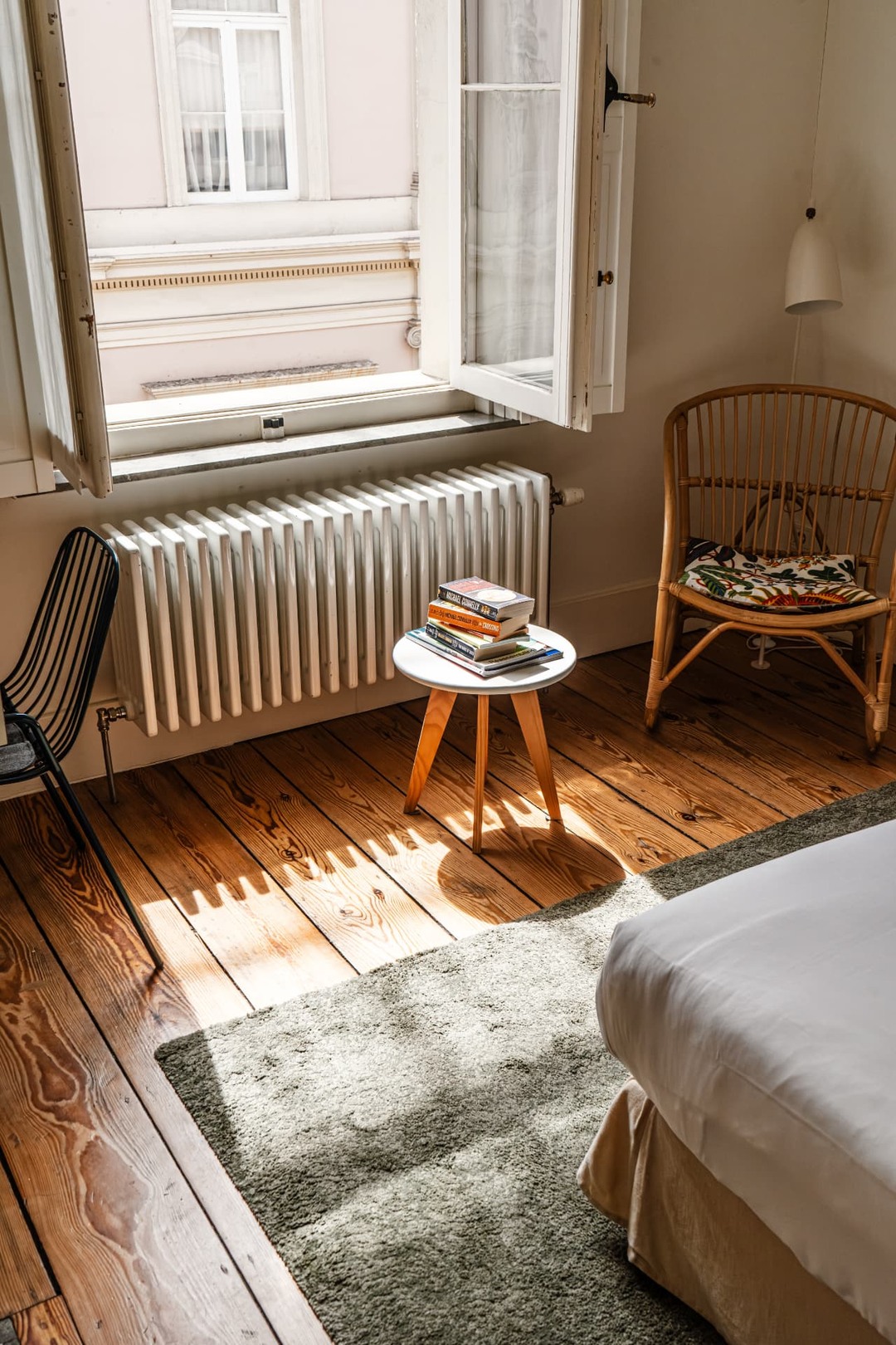 Lichte kamer van Hôtel des Galeries met houten vloer en open raam