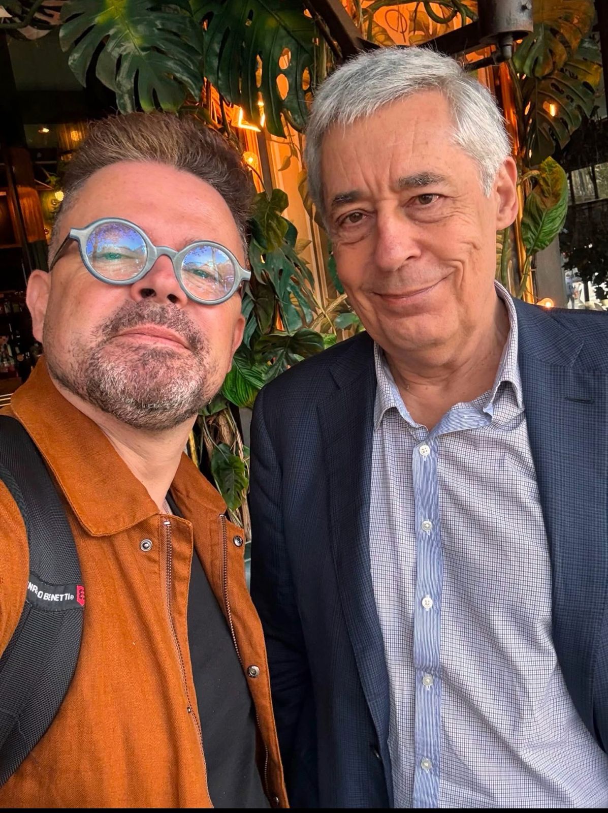 Twee mannen poseren samen in een groen café
