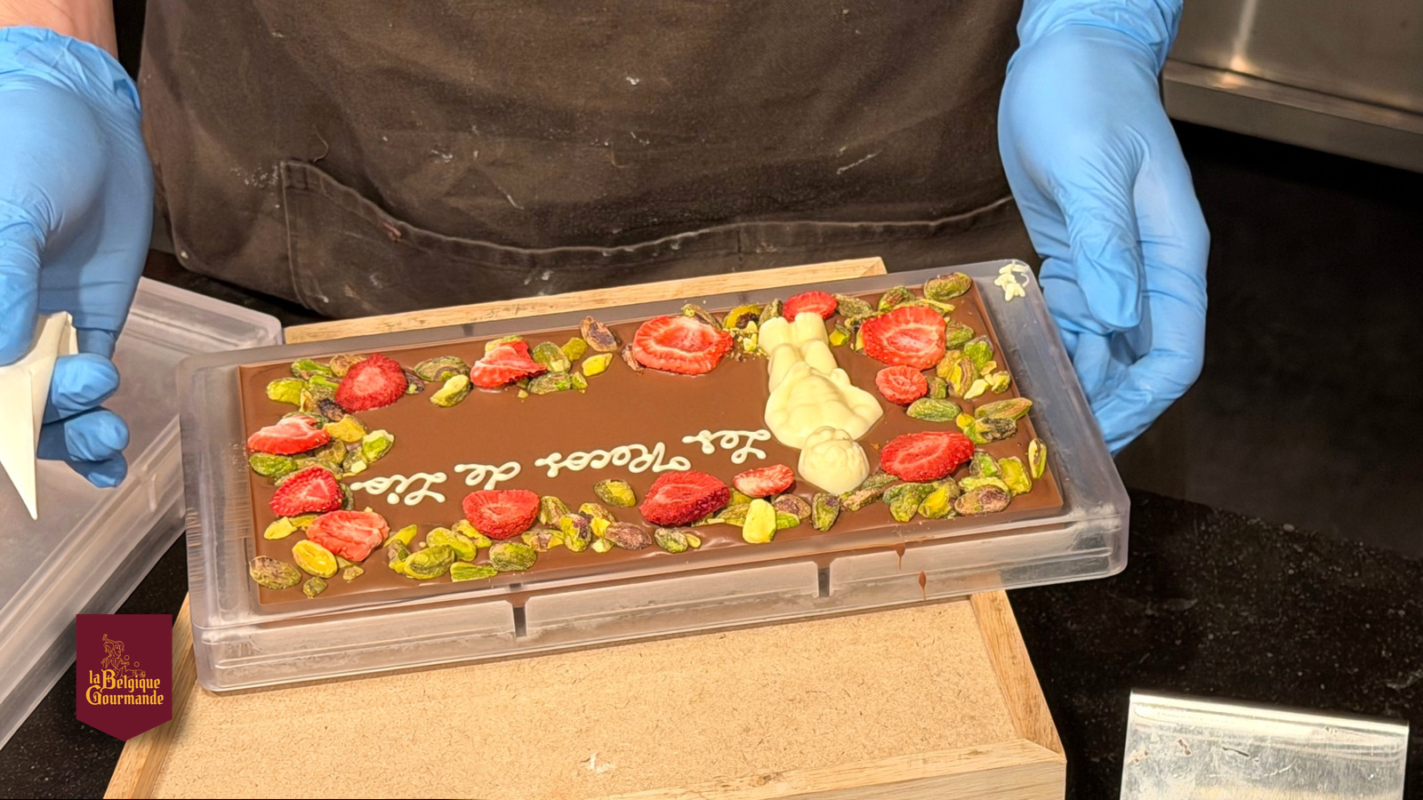 Une tablette personnalisée réalisée devant l’équipe de BXL Positive, rue de la Colline. © Bernard Frisque · BXL Positive Personalised chocolate bar with strawberries and pistachios, made at La Tabletterie in Brussels