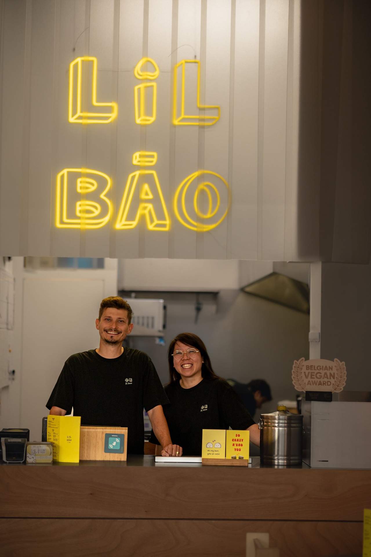 Portrait de Michal et de l’équipe de Lil Bao, cantine asiatique de Bruxelles, alignés devant leur comptoir