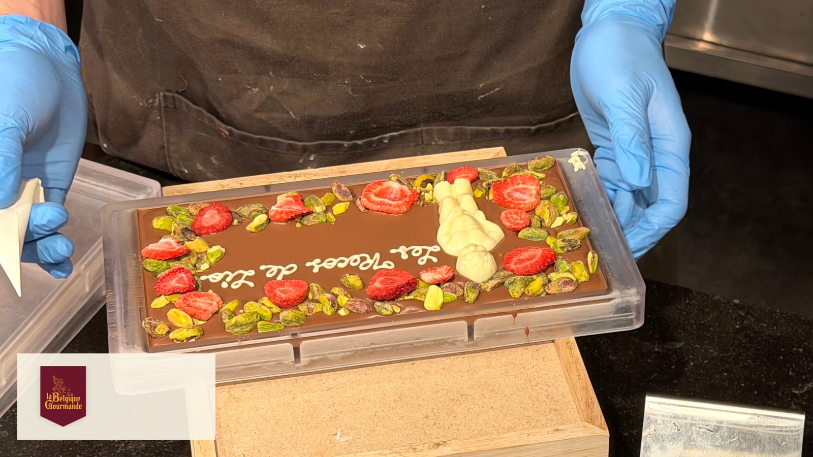 Une tablette personnalisée réalisée devant l’équipe de BXL Positive, rue de la Colline. © Bernard Frisque · BXL Positive Personalised chocolate bar with strawberries and pistachios, made at La Tabletterie in Brussels