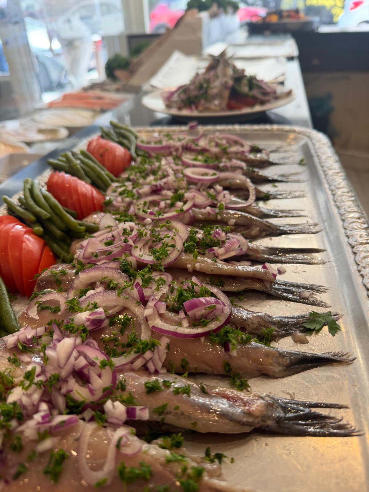 Plate of pickled herring with red onion and parsley