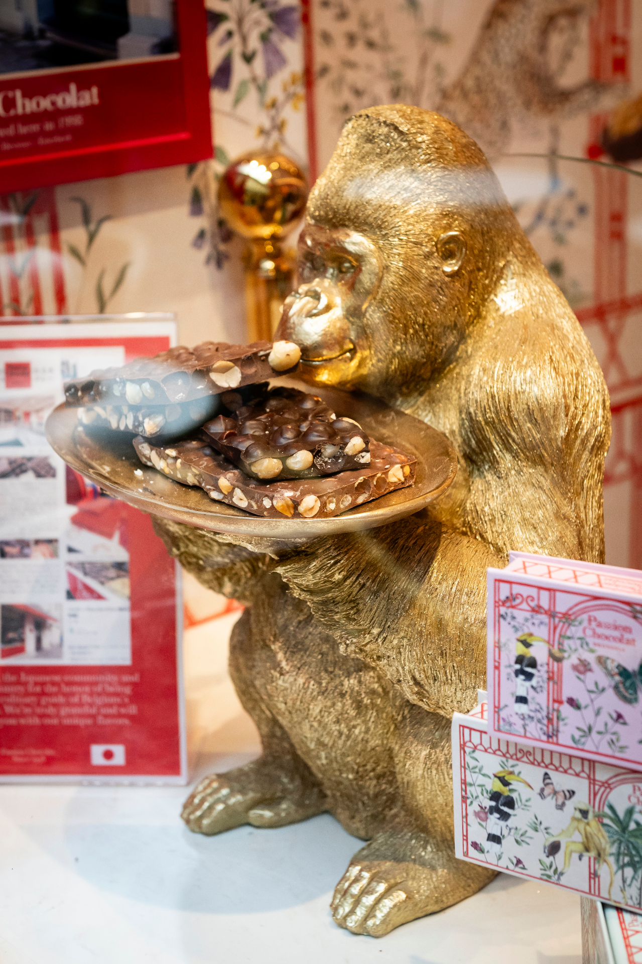 Gorille doré tenant un plateau de chocolats aux noisettes dans la vitrine Passion Chocolat
