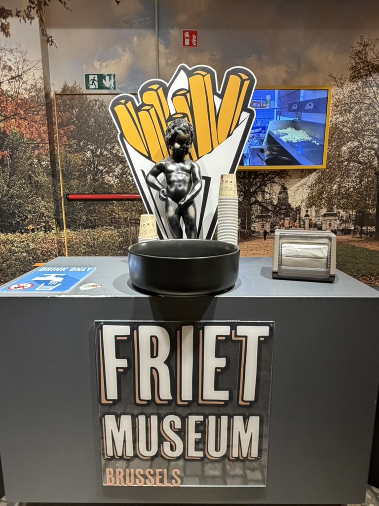 Friet Museum Brussels sign with a Manneken Pis figure on a fries backdrop