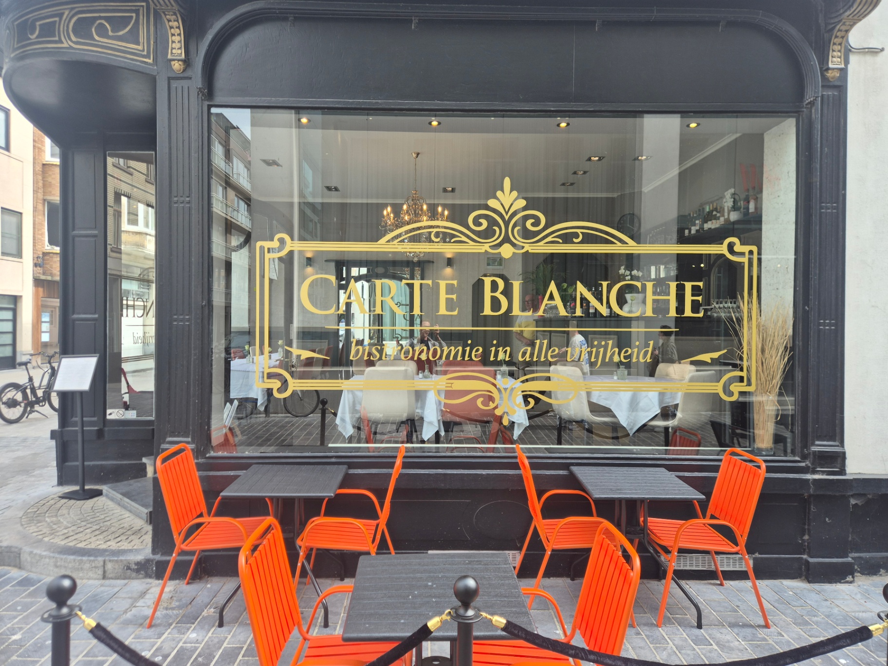 Façade et terrasse de Carte Blanche à Ostende avec logo Art nouveau doré Façade et terrasse de Carte Blanche à Ostende avec logo Art nouveau doré