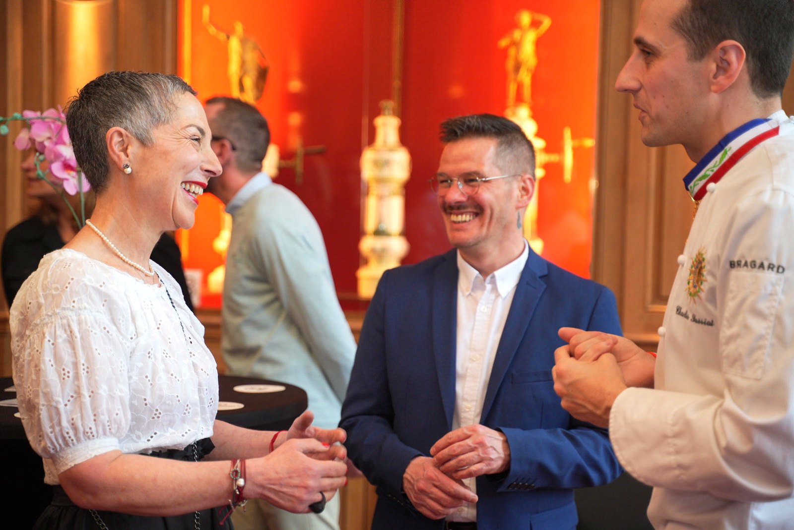 Chef Charles Sassiat in his embroidered chef jacket talking with guests