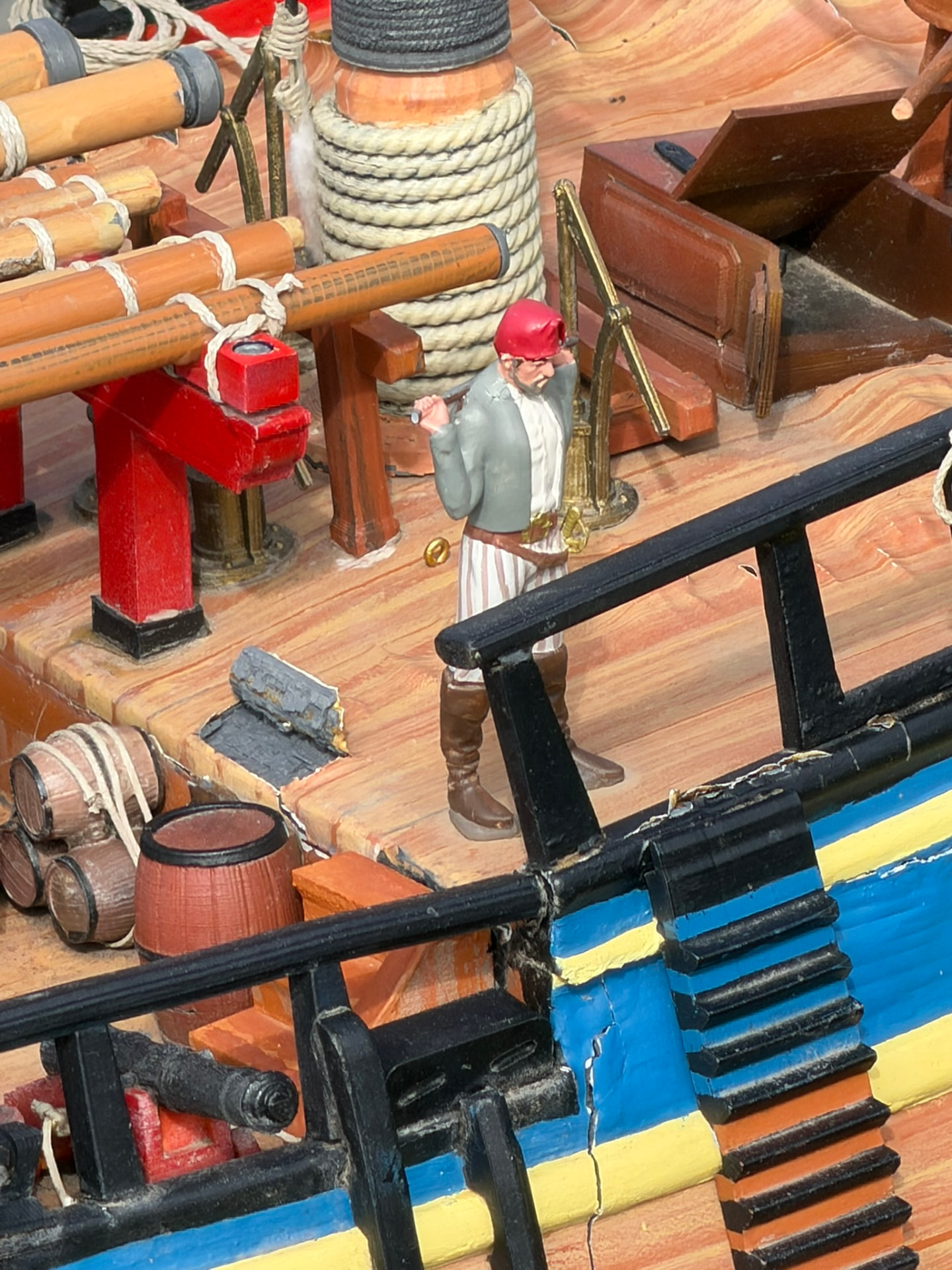 Un marin miniature sur le pont d’un bateau pirate, entre cordages et barriques