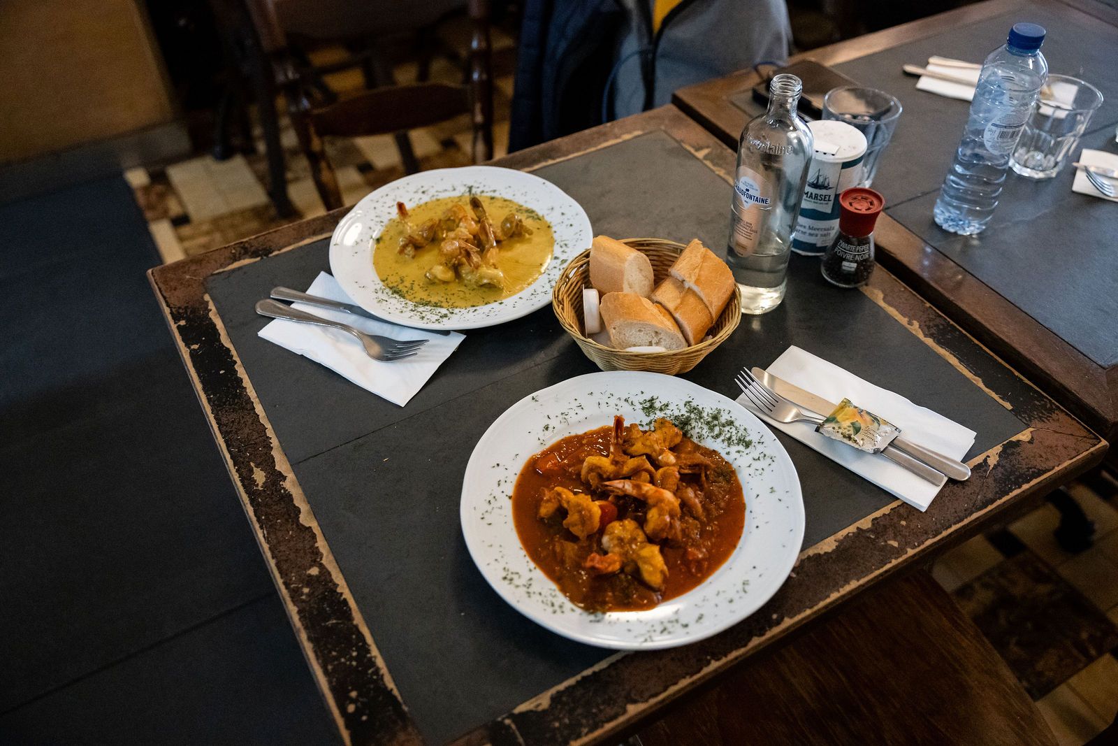 Table servie avec deux plats belges, du pain et de l’eau
