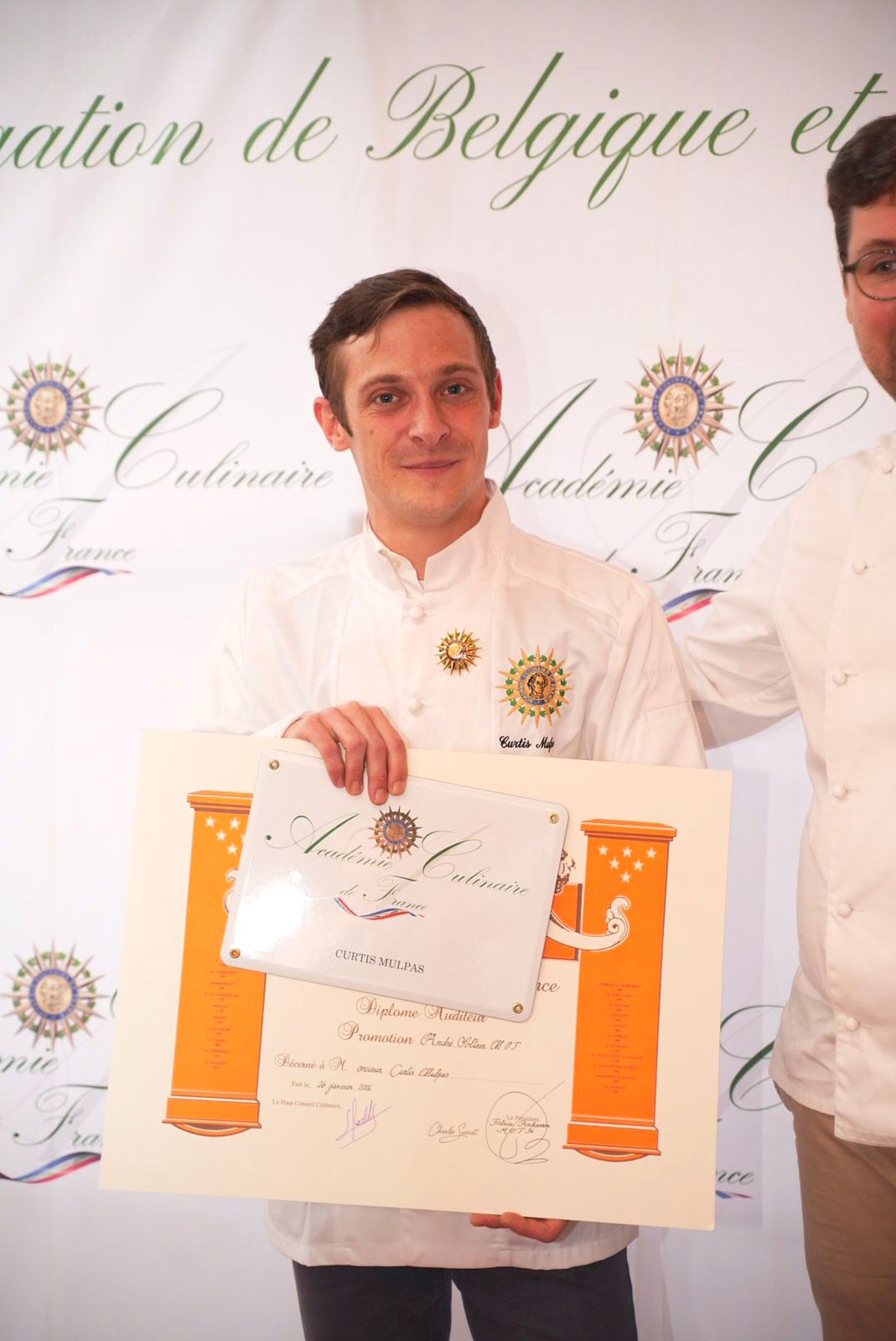 Chef Curtis Mulpas holding his Académie Culinaire de France diploma