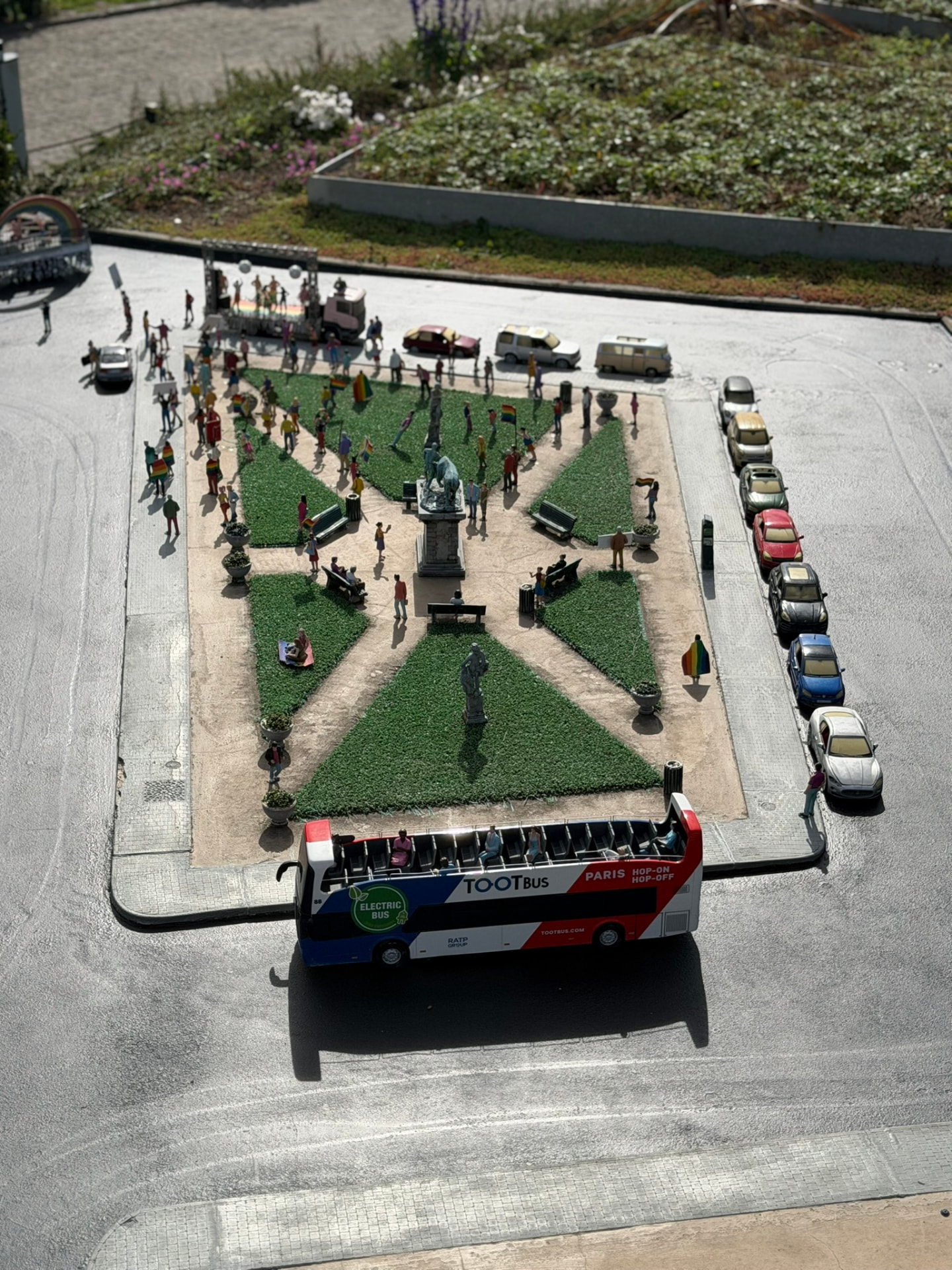 Une place parisienne miniature animée, avec le Tootbus de Paris et des figurines en fête
