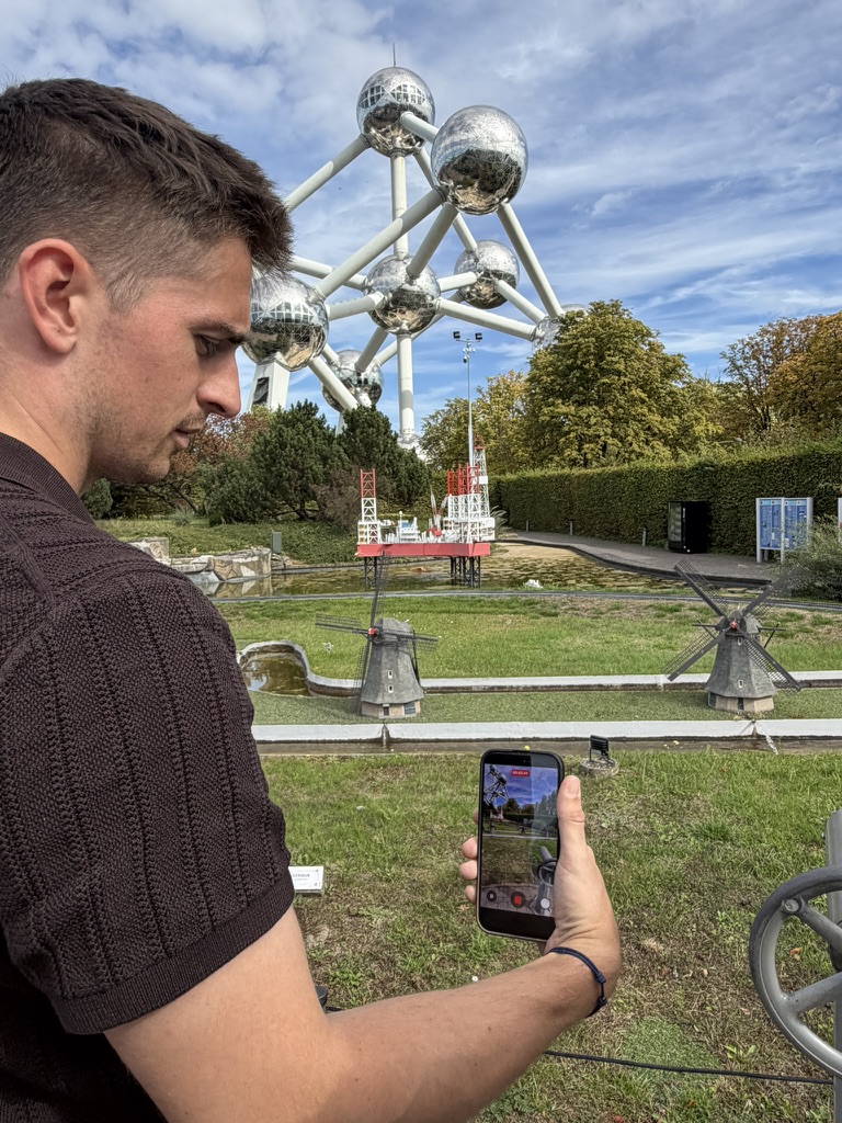 Un visiteur filme les moulins néerlandais miniatures, avec l’Atomium derrière